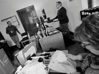 Director Jim Reed, left, checks in with CFO Jason Stripinis and Monica Robitaille at the Veterans Transition House office currently housed at the rectory of the now closed St. John church on County Street in New Bedford.   PHOTO PETER PEREIRA